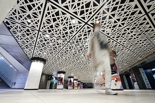 FILE - In this March 28, 2020, file, photo, a man walks at empty Ginza station underpass in Tokyo Saturday, March 28, 2020. Before the Olympics were postponed, Japan looked like it had coronavirus infections contained, even as they spread in neighboring countries. Now that the games have been pushed to next year, Tokyo&#146;s cases are spiking, and the city's governor is requesting that people stay home, even hinting at a possible lockdown.  (AP Photo/Eugene Hoshiko, File)