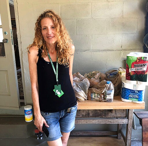 Instacart gig worker Summer Cooper, 39, delivers groceries, Saturday, March 28, 2020, in Belleair Beach, Fla. Cooper, 39, started working as an Instacart shopper in the Tampa Bay area in Florida recently after losing her position as a server at a hotel restaurant. (AP Photo/Curt Anderson)