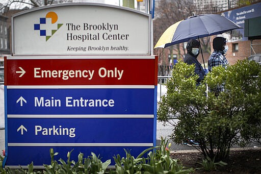 Patients wait in line while wearing protective masks and gloves for a COVID-19 test at Brooklyn Hospital Center, Sunday, March 29, 2020, in Brooklyn borough of New York. The new coronavirus causes mild or moderate symptoms for most people, but for some, especially older adults and people with existing health problems, it can cause more severe illness or death. (AP Photo/John Minchillo)