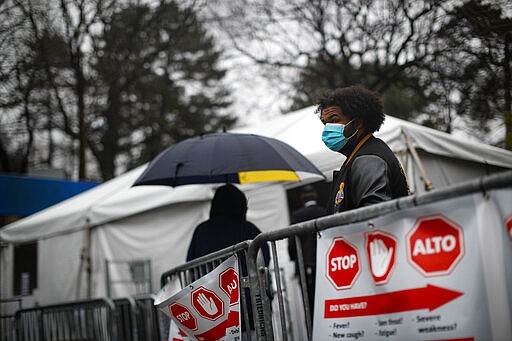 Patients wait in line while wearing protective masks and gloves for a COVID-19 test at Brooklyn Hospital Center, Sunday, March 29, 2020, in Brooklyn borough of New York. The new coronavirus causes mild or moderate symptoms for most people, but for some, especially older adults and people with existing health problems, it can cause more severe illness or death. (AP Photo/John Minchillo)