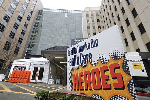 A sign posted in front of the emergency entrance of Harborview Medical Center gives thanks to health care workers during the coronavirus outbreak Saturday, March 28, 2020, in Seattle. Harborview and University of Washington Medicine are preparing a &quot;surge plan&quot; that will enable its hospitals to better respond to the coronavirus outbreak. Under the plan, ambulatory patients with respiratory illness symptoms will be separated from other patients when they arrive at hospitals' emergency departments and be directed to a new treatment area in a tent outside of the emergency department. (AP Photo/Elaine Thompson)
