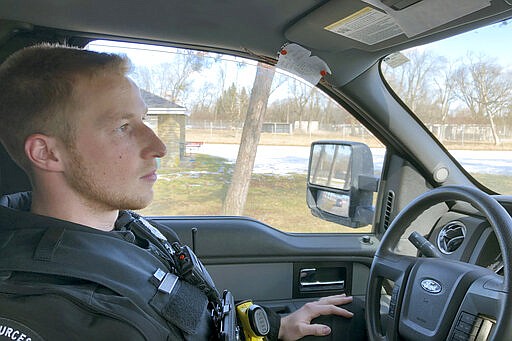 In this March 5, 2020, photo, Wisconsin Department of Natural Resources Warden Austin Schumacher recalls how he rescued a 13-year-old boy who vanished in a marsh in November, as he sits in his vehicle in the Edgerton, Wis., park where the search began. This month, Schumacher received the DNR&#146;s Lifesaving Award. His training officer, Warden Tim Werner, said he wasn't surprised at Schumacher's valor. Nor was he surprised that Schumacher&#146;s woodland expertise had had been put to use. (AP Photo/Todd Richmond)