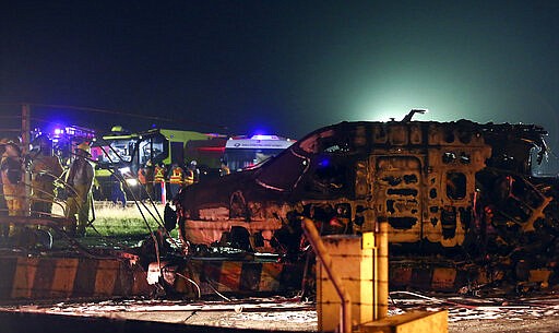 Firemen and rescuers talk beside the remains of a Lion Air, West Wind 24 aircraft after it caught fire during take off at Manila's International Airport in Philippines on Sunday, March 29, 2020. A plane carrying eight people has caught fire while attempting to take off from Manila's airport on a flight bound for Japan, killing all those on board, officials said. (AP Photo)