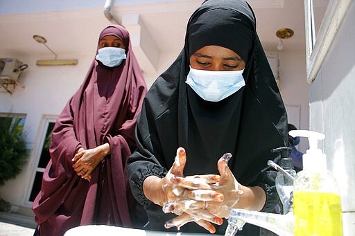 Somali female wash their hands during coronavirus awareness training conducted by the local paramedics and doctors in Somali capital Mogadishu, Thursday, March, 19, 2020. Somalia's government has announced the closure of schools universities and a ban or large gathering and events for two weeks effective. For most people, the new coronavirus causes only mild or moderate symptoms such as fever and cough and the vast majority recover in 2-6 weeks but for some especially older adults and the people with existing health issues, the virus that causes COVID-19 can result in more severe illness, including pneumonia.(AP Photo/Farah Abdi Warsameh)