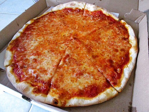 This March 24, 2020 photo shows a pizza made by Michael Morin, co-owner of Federico's Pizza in Belmar N.J. He and his brother took out a $50,000 line of credit to ensure that their employees can stay on the payroll for at least two months during the virus outbreak. That prompted an outpouring of donations from customers wanting to send pizzas to hospital workers and first responders. (AP Photo/Wayne Parry)