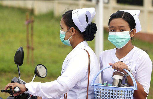 FILE - In this July 25, 2017 file photo, nurses cover their faces with masks to protect from the spread of the swine flu outside the Naypyitaw hospital in Naypyitaw, Myanmar. On Tuesday, March 10, 2020, the U.S. Centers for Disease Control and Prevention posted guidance to doctors and nurses that surgical masks are OK to wear when treating patients who may be sick from the new coronavirus &#151; a decision made in reaction to possible shortages of a more protective respirator masks. (AP Photo/Aung Shine Oo)