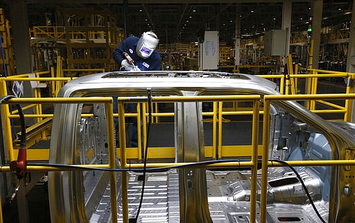 In this Nov. 11, 2014 photo, Ron Hudgins welds a 2015 Ford F-150 cab at the Dearborn Truck Plant in Dearborn, Mich. General Motors, Ford, jet engine maker Rolls-Royce and other companies are talking to their governments about repurposing idled factories to produce vital goods to fight the coronavirus such as ventilators and surgical masks. On Friday, March 20, 2020 President Donald Trump invoked the Korean War-era Defense Production Act, allowing the government to marshal the private sector to fight the COVID-19 pandemic. Although it allows the government to steer factories to overcome shortages, makers of heavy goods such as cars and trucks can't just flip a switch and produce something else. (AP Photo/Paul Sancya)