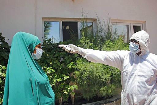 A Somali paramedic trains people to use corona kits during awareness training in Mogadishu, Somalia Thursday, March, 19, 2020. The Somali government has announced the closure schools universities and a ban or large gathering and events for two weeks effective. For most people, the new coronavirus causes only mild or moderate symptoms such as fever and cough and the vast majority recover in 2-6 weeks but for some especially older adults and the people with existing health issues, the virus that causes COVID-19 can result in more severe illness, including pneumonia.(AP Photo/Farah Abdi Warsameh)