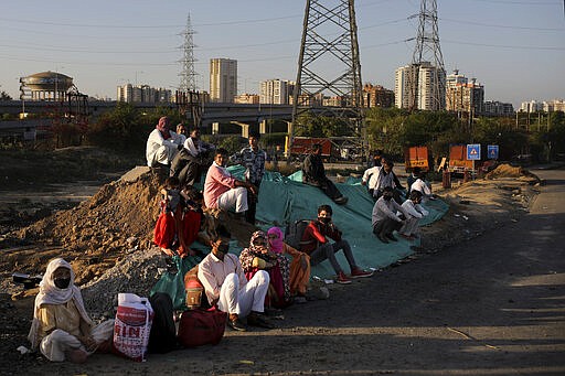 A group of Indian migrant workers rest as they wait for transportation to their village following a lockdown amid concern over spread of coronavirus in New Delhi, India, Saturday, March 28, 2020. Authorities sent a fleet of buses to the outskirts of India's capital on Saturday to meet an exodus of migrant workers desperately trying to reach their home villages during the world's largest coronavirus lockdown. Thousands of people, mostly young male day laborers but also families, fled their New Delhi homes after Prime Minister Narendra Modi announced a 21-day lockdown that began on Wednesday and effectively put millions of Indians who live off daily earnings out of work. (AP Photo/Altaf Qadri)