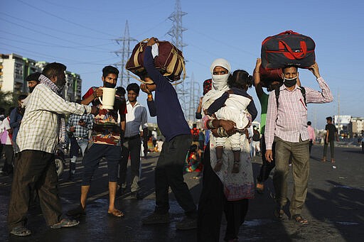 Locals provide drinking water to Indian migrant laborers making their way on foot to their respective villages following a lockdown amid concern over spread of coronavirus in New Delhi, India, Saturday, March 28, 2020. Authorities sent a fleet of buses to the outskirts of India's capital on Saturday to meet an exodus of migrant workers desperately trying to reach their home villages during the world's largest coronavirus lockdown. Thousands of people, mostly young male day laborers but also families, fled their New Delhi homes after Prime Minister Narendra Modi announced a 21-day lockdown that began on Wednesday and effectively put millions of Indians who live off daily earnings out of work. (AP Photo/Altaf Qadri)