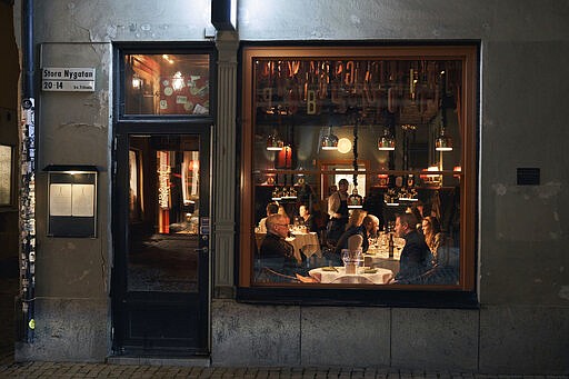 FILE - People sit in a restaurant in Stockholm, Sweden, Wednesday, March 25, 2020. The streets of Stockholm are quiet but not deserted. People still sit at outdoor cafes in the center of Sweden's capital. After a long, dark Scandinavian winter, the coronavirus pandemic is not keeping Swedes at home even while citizens in many parts of the world are sheltering in place and won't find shops or restaurants open on the few occasions they are permitted to venture out. (AP Photo/David Keyton, File)