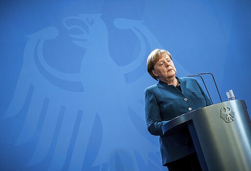 FILE - In this Sunday, March 22, 2020, file photo, German Chancellor Angela Merkel speaks at a news conference about the new coronavirus, in Berlin. World War II references are now heard daily, not because another momentous 75th anniversary, Victory in Europe Day approaches in May but because of the coronavirus. (Michael Kappeler/Pool photo via AP, File)