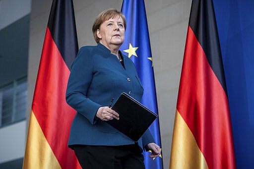 German Chancellor Angela Merkel arrives for a press conference about coronavirus, in Berlin, Sunday, March 22, 2020. German authorities have issued a ban on more than two people meeting outside of their homes, which they believe will be easier to follow than locking people in their homes. The vast majority of people recover from the new coronavirus. According to the World  Health Organization, most people recover in about two to six weeks, depending on the severity of the illness. (Michael Kappeler/Pool photo via AP)