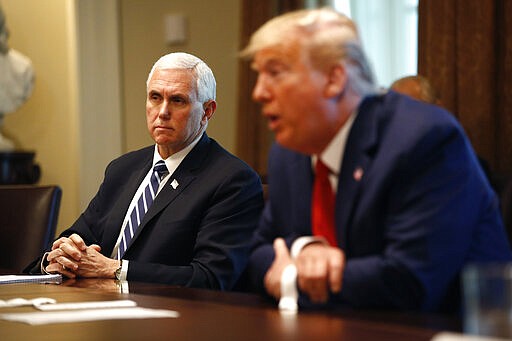 President Donald Trump speaks as Vice President Mike Pence listens during a meeting with supply chain distributors in the Cabinet Room of the White House, Sunday, March 29, 2020, in Washington. (AP Photo/Patrick Semansky)