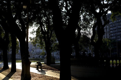 A homeless man sits on a bench in front of Congress in Buenos Aires, Argentina, Sunday, March 29, 2020. The Argentine government ordered a forced lock down until end of March to contain the spread of the new coronavirus. COVID-19 disease causes mild or moderate symptoms for most people, but for some, especially older adults and people with existing health problems, it can cause more severe illness or death. (AP Photo/Natacha Pisarenko)