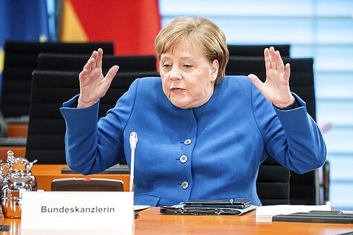 German Chancellor Angela Merkel gestures during the weekly cabinet meeting at the Chancellery in Berlin, Germany, Wednesday, March 18, 2020. Due to the new coronavirus outbreak the meeting was reloacted to the International Room to provide more space between the participants.  For most people, the new coronavirus causes only mild or moderate symptoms. For some it can cause more severe illness, especially in older adults and people with existing health problems. (Michael Kappeler/DPA via AP, Pool)