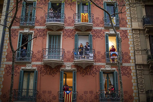 People applaud from their houses in support of the medical staff that are working on the COVID-19 virus outbreak in Barcelona, Spain, Sunday, March 29, 2020. The new coronavirus causes mild or moderate symptoms for most people, but for some, especially older adults and people with existing health problems, it can cause more severe illness or death. (AP Photo/Emilio Morenatti)