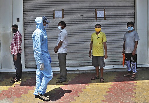 People wearing masks stand in a queue to receive food being distributed during lockdown in Mumbai, India, Sunday, March 29, 2020. Indian Prime Minister Narendra Modi apologized to the public on Sunday for imposing a three-week national lockdown, calling it harsh but &quot;needed to win&quot; the battle against the coronavirus pandemic. The new coronavirus causes mild or moderate symptoms for most people, but for some, especially older adults and people with existing health problems, it can cause more severe illness or death. (AP Photo/Rafiq Maqbool)