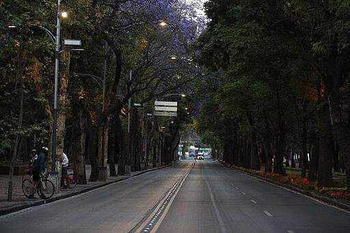 Little traffic is seen on the usually crowded Paseo de la Reforma in Mexico City, at dusk Saturday, March 28, 2020. On Thursday, the federal government shut down because of the coronavirus for all but essential services, and health officials have urged businesses to keep employees at home for all but essential activities. (AP Photo/Rebecca Blackwell)