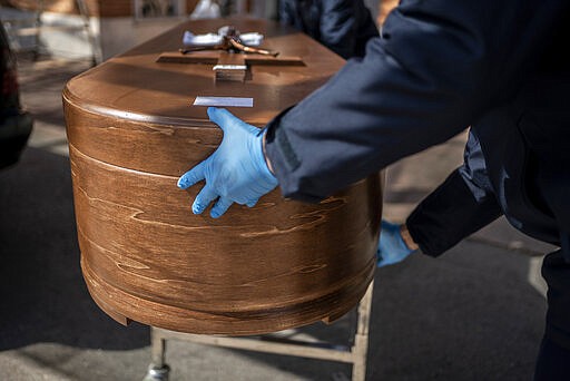 The coffin containing remains of a victim of the COVID-19 is taken for cremation at the Almudena cemetery in Madrid, Spain, Saturday March 28, 2020. In Spain, where stay-at-home restrictions have been in place for nearly two weeks, the official number of deaths is increasing daily. The new coronavirus causes mild or moderate symptoms for most people, but for some, especially older adults and people with existing health problems, it can cause more severe illness or death. (AP Photo/Olmo Calvo)