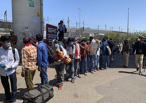 Hundreds wait in line to cross a border to the neighboring state of Uttar Pradesh, in New Delhi, India, Sunday, March 29, 2020. An unprecedented lockdown order, which came into effect on Wednesday has caused tens of thousands of people, mostly young male day laborers but also families, to flee their New Delhi homes, and has effectively put millions of Indians who live off daily earnings out of work. Indian Prime Minister Narendra Modi apologized to the public on Sunday for imposing a three-week national lockdown, calling it harsh but &#147;needed to win&#148; the battle against the coronavirus pandemic. The new coronavirus causes mild or moderate symptoms for most people, but for some, especially older adults and people with existing health problems, it can cause more severe illness or death. (AP Photo/Emily Schmall)