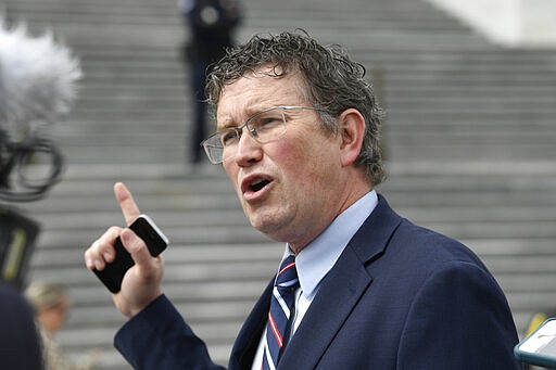 FILE - In this March 27, 2020 file photo Rep. Thomas Massie, R-Ky., talks to reporters before leaving Capitol Hill in Washington. He drew the president's wrath for seeking to slow congressional approval of a $2.2 trillion coronavirus-relief package, and now Massie is doubling down on the tactic and raking in campaign cash for his reelection bid. Massie's campaign said Monday, March 30, 2020 it had raised more than $110,000 over a three-day period when the Kentucky Republican was in the spotlight for his failed attempt to force a roll call vote on the relief on Capitol Hill. (AP Photo/Susan Walsh, file)