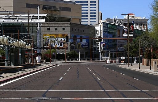 An empty street is devoid of vehicular traffic and pedestrians due to the coronavirus Sunday, March 29, 2020, in Phoenix. (AP Photo/Ross D. Franklin)