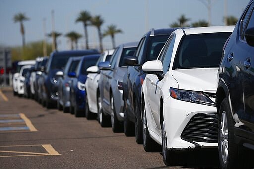 Lines of unused rental cars are stored in a parking area at Phoenix Sky Harbor Airport as less people are traveling due to the coronavirus Sunday, March 29, 2020, in Phoenix. (AP Photo/Ross D. Franklin)