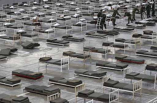 In this March 24, 2020, photo, Serbian soldiers set up beds for treatment of possible COVID-19 infected patients inside of the Belgrade Fair, Serbia. In the ex-communist Europe and elsewhere, rulers are assuming more power while they introduce harsh measures they say are necessary to halt coronavirus spread.&#160; (AP Photo/Darko Vojinovic)