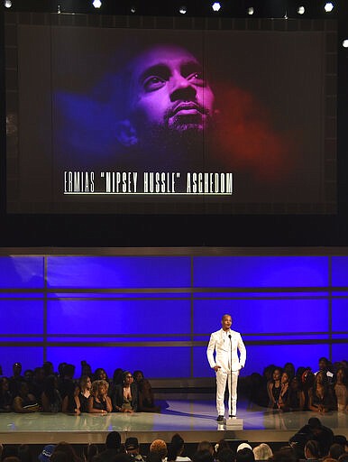 FILE - This June 23, 2019 file photo shows Tip &quot;T.I.&quot; Harris presents the humanitarian award to late rapper Nipsey Hussle at the BET Awards  in Los Angeles. Hussle, 33, was shot and killed outside his Los Angeles clothing store on March 31, 2019. A year after Hussle's death, his popularity and influence are as strong as ever. He won two posthumous Grammys in January, he remains a favorite of his hip-hop peers and his death has reshaped his hometown of Los Angeles in some unexpected ways. (Photo by Chris Pizzello/Invision/AP, File)