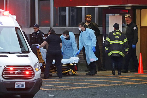 Police, fire, and EMS responders &#151; some wearing masks, gowns, and gloves to protect against the transmission of the new coronavirus, respond to a medical call in Seattle Tuesday, March 24, 2020. First responders across the country are now responding to even routine calls wearing personal protective equipment to try and slow the outbreak of the new coronavirus, which causes mild or moderate symptoms for most people, but for some, especially older adults and people with existing health problems, it can cause more severe illness or death. (AP Photo/Ted S. Warren)