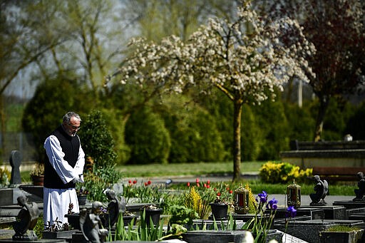 A priest gives funeral rites at Salvador cemetery during the coronavirus outbreak, near to Vitoria, northern Spain, Monday, March 30, 2020. The new coronavirus causes mild or moderate symptoms for most people, but for some, especially older adults and people with existing health problems, it can cause more severe illness or death. AP Photo/Alvaro Barrientos)