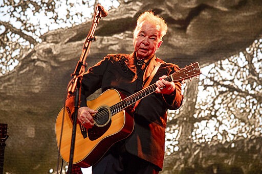 FILE - This June 15, 2019 file photo shows John Prine performing at the Bonnaroo Music and Arts Festival in Manchester, Tenn. The family of John Prine says the singer-songwriter is critically ill and has been placed on a ventilator while being treated for COVID-19-type symptoms. A message posted on Prine's Twitter page Sunday, March 29, 2020 said the &#147;Angel from Montgomery&#148; singer has been hospitalized since Thursday and his condition worsened on Saturday. (Photo by Amy Harris/Invision/AP, File)