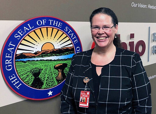 FILE - In this Jan. 22, 2020, file photo, Annette Chambers-Smith, director of the Ohio Department of Rehabilitation and Correction, poses outside her office in Columbus, Ohio. An Ohio prison employee tested positive for the coronavirus, the state reported Sunday night,  March 29, 2020, marking the first such occurrence in Ohio at a time of growing national fears about the impact of the virus in crowded jails and prisons. Systemwide, the prisons department is now allowing alcohol-based hand sanitizer and limiting prison access to employees and necessary contractors who undergo health screens, said agency Director Annette Chambers-Smith.  (AP Photo/Andrew Welsh-Huggins,File)