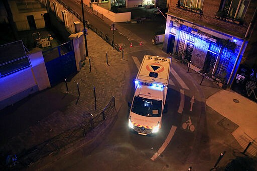 In this photo taken Thursday, March 26, 2020 an ambulance of the Civil Protection service is parked in a street to evacuate man suspected of having the coronavirus infection in Paris. (AP Photo/Michel Euler)