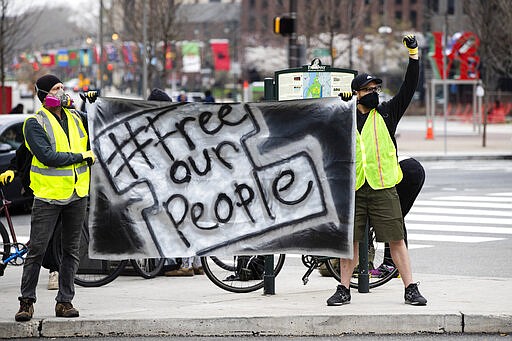 Protesters call for officials to release people from jails, prisons, and immigration detention centers in response to the coronavirus, as they demonstrate outside City Hall in Philadelphia, Monday, March 30, 2020. (AP Photo/Matt Rourke)