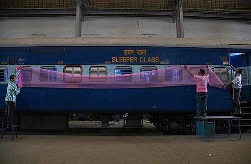 Indian railway employees fix mosquito nets as they work to convert a train coach into an isolation ward for the fight against the new coronavirus in Gauhati, India, Sunday, March 29, 2020. Indian Prime Minister Narendra Modi apologized to the public on Sunday for imposing a three-week national lockdown, calling it harsh but &quot;needed to win&quot; the battle against the coronavirus pandemic. The new coronavirus causes mild or moderate symptoms for most people, but for some, especially older adults and people with existing health problems, it can cause more severe illness or death. (AP Photo/Anupam Nath)