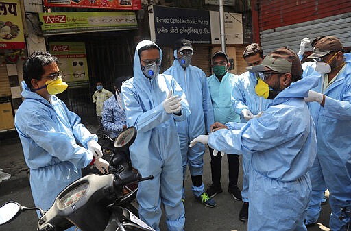 Members of a voluntary organization wear protective gear before distributing food to people in Mumbai, India, Sunday, March 29, 2020. Indian Prime Minister Narendra Modi apologized to the public on Sunday for imposing a three-week national lockdown, calling it harsh but &quot;needed to win&quot; the battle against the coronavirus pandemic. The new coronavirus causes mild or moderate symptoms for most people, but for some, especially older adults and people with existing health problems, it can cause more severe illness or death. (AP Photo/Rafiq Maqbool)