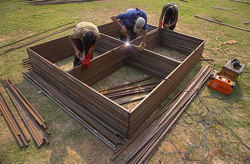 Indians work to prepare a quarantine center at the Sarusojai sports complex in Gauhati, India, Saturday, March 28, 2020. The new coronavirus causes mild or moderate symptoms for most people, but for some, especially older adults and people with existing health problems, it can cause more severe illness or death. (AP Photo/Anupam Nath)