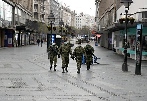 In this March 26, 2020, photo, Serbian army soldiers patrol in Belgrade's main pedestrian street, in Serbia. In the ex-communist Europe and elsewhere, rulers are assuming more power while they introduce harsh measures they say are necessary to halt coronavirus spread. (AP Photo/Darko Vojinovic)