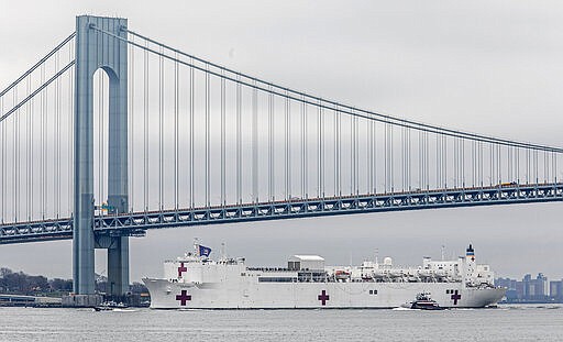 CORRECTS BYLINE TO BEBETO MATTHEWS, NOT SETH WENIG - The Navy hospital ship USNS Comfort passes under the Verrazzano-Narrows Bridge on its way to docking in New York, Monday, March 30, 2020. The ship has 1,000 beds and 12 operating rooms that could be up and running within 24 hours of its arrival on Monday morning. It's expected to bolster a besieged health care system by treating non-coronavirus patients while hospitals treat people with COVID-19. (AP Photo/Bebeto Matthews)