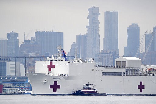 The Navy hospital ship USNS Comfort passes lower Manhattan on its way to docking in New York, Monday, March 30, 2020. The ship has 1,000 beds and 12 operating rooms that could be up and running within 24 hours of its arrival on Monday morning. It's expected to bolster a besieged health care system by treating non-coronavirus patients while hospitals treat people with COVID-19. (AP Photo/Seth Wenig)