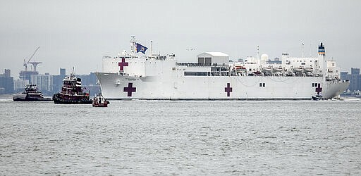 The Navy hospital ship USNS Comfort sails into New York, Monday March 30, 2020. The ship has 1,000 beds and 12 operating rooms that could be up and running within 24 hours of its arrival on Monday morning. It's expected to bolster a besieged health care system by treating non-coronavirus patients while hospitals treat people with COVID-19.  (AP Photo/Bebeto Matthews)