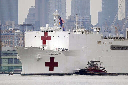 The Navy hospital ship USNS Comfort passes lower Manhattan on its way to docking in New York, Monday, March 30, 2020. The ship has 1,000 beds and 12 operating rooms that could be up and running within 24 hours of its arrival on Monday morning. It's expected to bolster a besieged health care system by treating non-coronavirus patients while hospitals treat people with COVID-19.  (AP Photo/Seth Wenig)