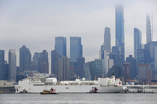 The Navy hospital ship USNS Comfort passes the Manhattan skyline on its way to docking in New York, Monday, March 30, 2020. The ship has 1,000 beds and 12 operating rooms that could be up and running within 24 hours of its arrival on Monday morning. It's expected to bolster a besieged health care system by treating non-coronavirus patients while hospitals treat people with COVID-19. (AP Photo/Seth Wenig)