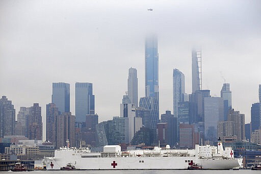 The Navy hospital ship USNS Comfort passes the Manhattan skyline on its way to docking in New York, Monday, March 30, 2020. The ship has 1,000 beds and 12 operating rooms that could be up and running within 24 hours of its arrival on Monday morning. It's expected to bolster a besieged health care system by treating non-coronavirus patients while hospitals treat people with COVID-19. (AP Photo/Seth Wenig)