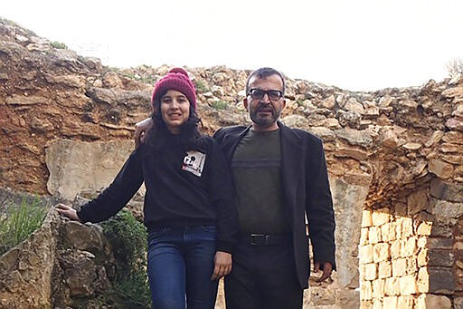 In this March 12, 2020 photo made available by Reem Mousa, Ismail Mousa and his daughter Anisa of Selbyville, Delaware, pose for a photograph while sightseeing near the Palestinian village of Qaryout in the West Bank. Mousa and his daughter found themselves stranded and separated from each other after their travels plans and efforts to return home were thwarted because of the coronavirus pandemic. (Reem Mousa via AP)