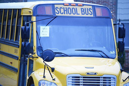 This wi-fi-enabled school bus, seen at an apartment complex on Thursday, March 27, 2020, in Winnsboro, S.C., is one of many being sent to rural and lower-income areas around South Carolina to help students with distance learning during the new coronavirus outbreak. (AP Photo/Meg Kinnard)