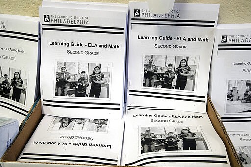 In this Wednesday, March 25, 2019, photo are learning guides to be distributed to students at John H. Webster Elementary School in Philadelphia. Only about half of the district&#146;s high school students have a laptop or tablet and home internet service. As schools now appear likely to be closed due to the coronavirus for longer than anticipated, the district plans to buy 50,000 Chromebooks and begin online instruction by mid-April. (AP Photo/Matt Rourke)
