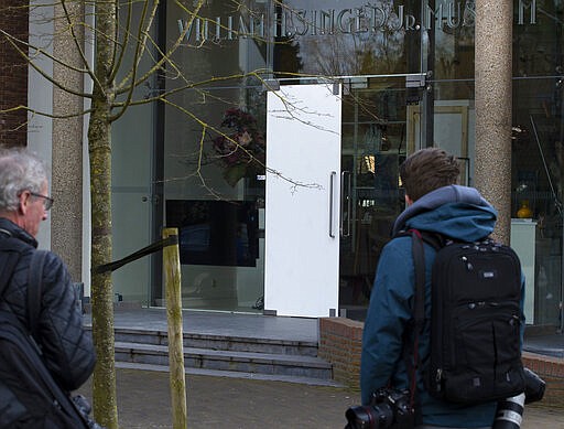 Journalists look at the damaged glass door of the Singer Museum in Laren, Netherlands, Monday March 30, 2020, where a Van Gogh painting was stolen. The Dutch museum that is currently closed to prevent the spread of the coronavirus says a painting by the Dutch master titled &quot;Spring Garden&quot; was stolen in a smash-and-grab raid overnight. (AP Photo/Peter Dejong)